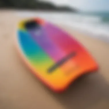 Close-up of a colorful bodyboard resting on the sand