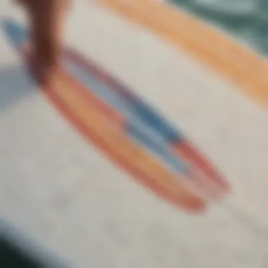 A close-up of a textured surfboard sticker being applied to the board.