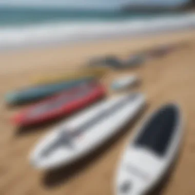 A collection of various used jet surfboards displayed on a sandy beach.