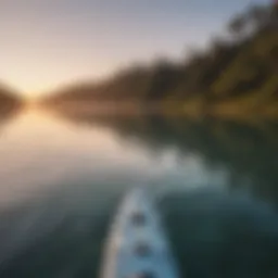 A scenic view of a paddle boarder gliding over calm waters at sunrise