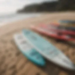 Diverse paddle board sizes displayed on a sandy beach