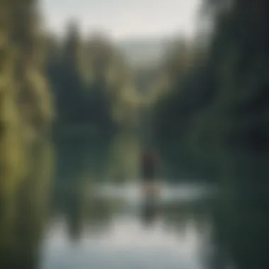 A person paddling on a tranquil lake with a properly sized board